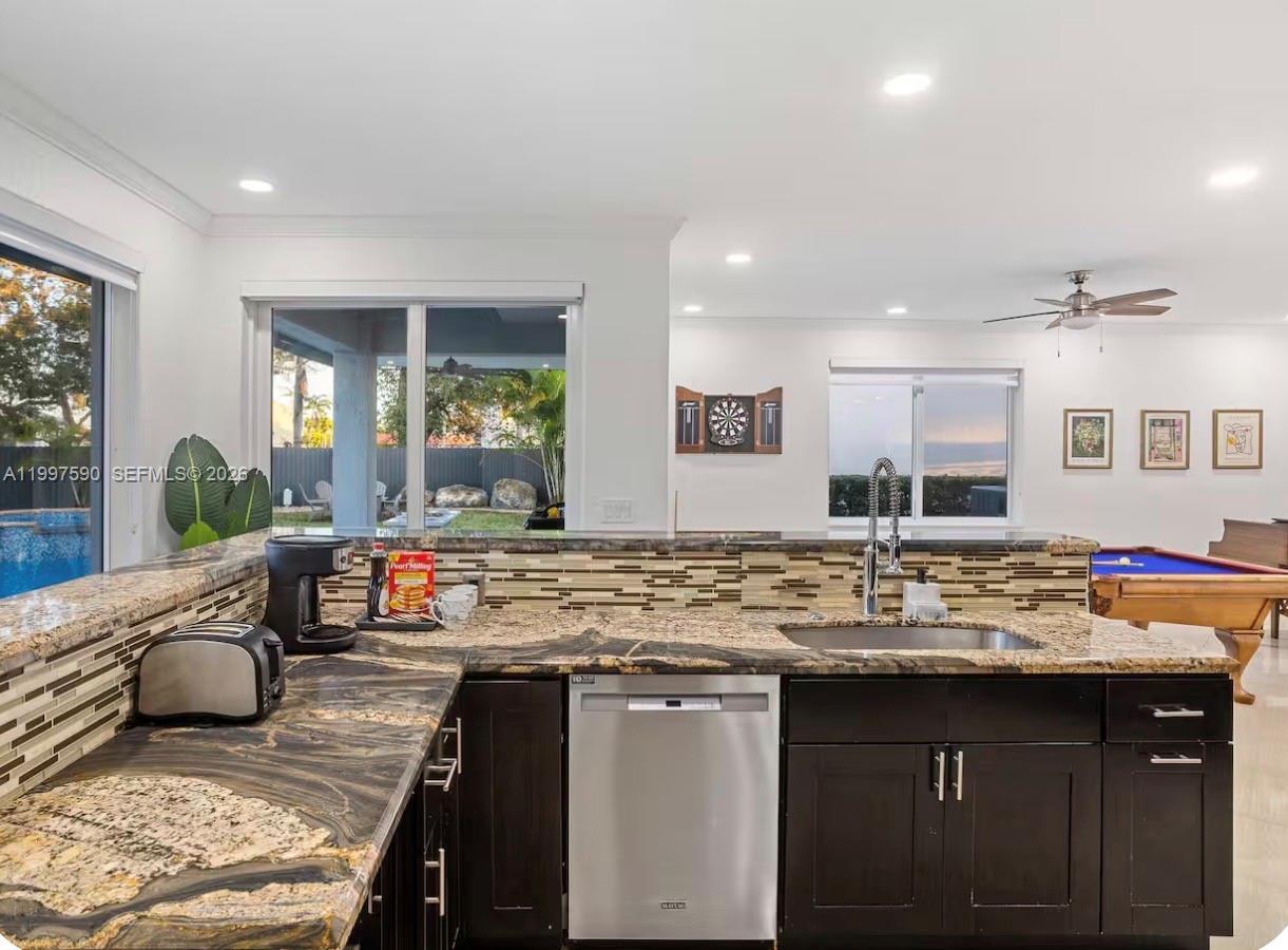 15411 Southwest 36th Terrace Miami, FL 33185 - Photo 12 of 45 a kitchen with a granite countertop sink stove and wooden cabinets