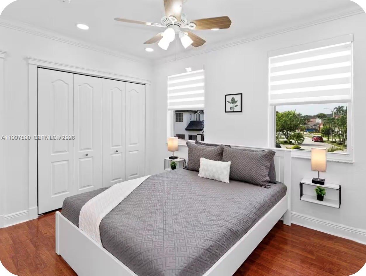 15411 Southwest 36th Terrace Miami, FL 33185 - Photo 21 of 45 a bedroom with a large bed and a chandelier