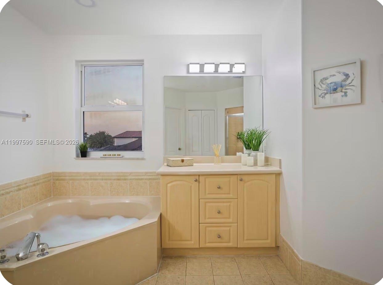 15411 Southwest 36th Terrace Miami, FL 33185 - Photo 23 of 45 a bathroom with a bathtub a mirror a double vanity sink and vanity