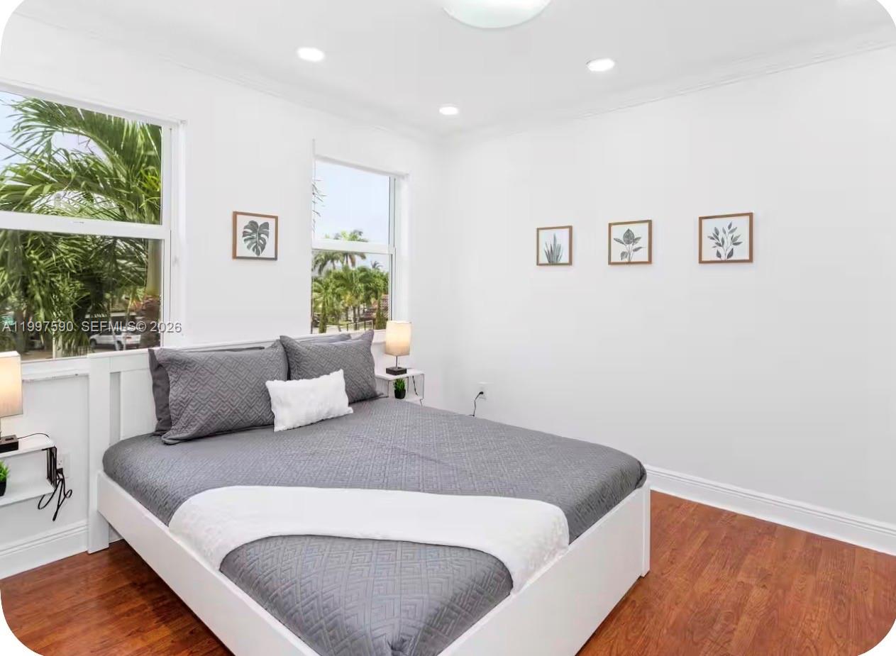 15411 Southwest 36th Terrace Miami, FL 33185 - Photo 24 of 45 a bedroom with a large bed and a potted plant