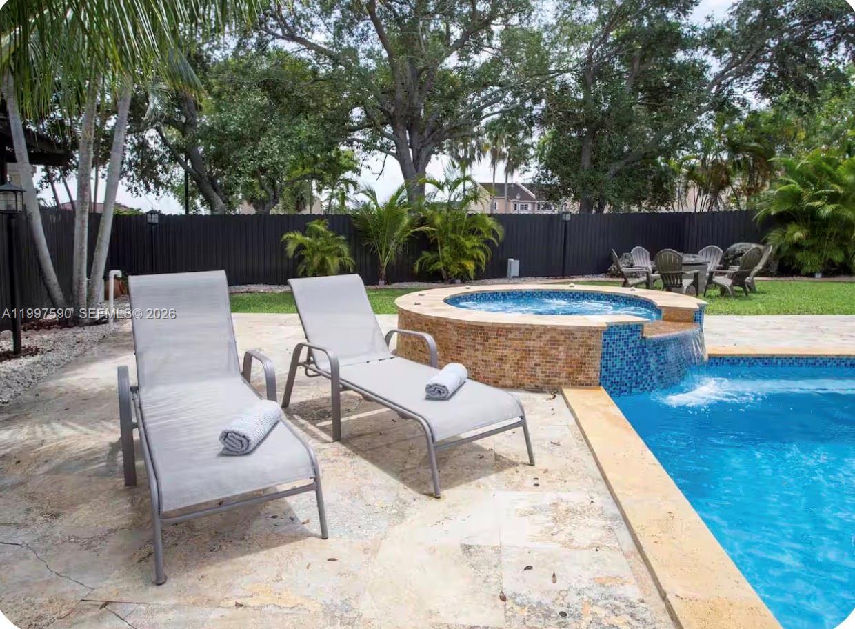 15411 Southwest 36th Terrace Miami, FL 33185 - Photo 32 of 45 a view of a swimming pool with chairs and a table