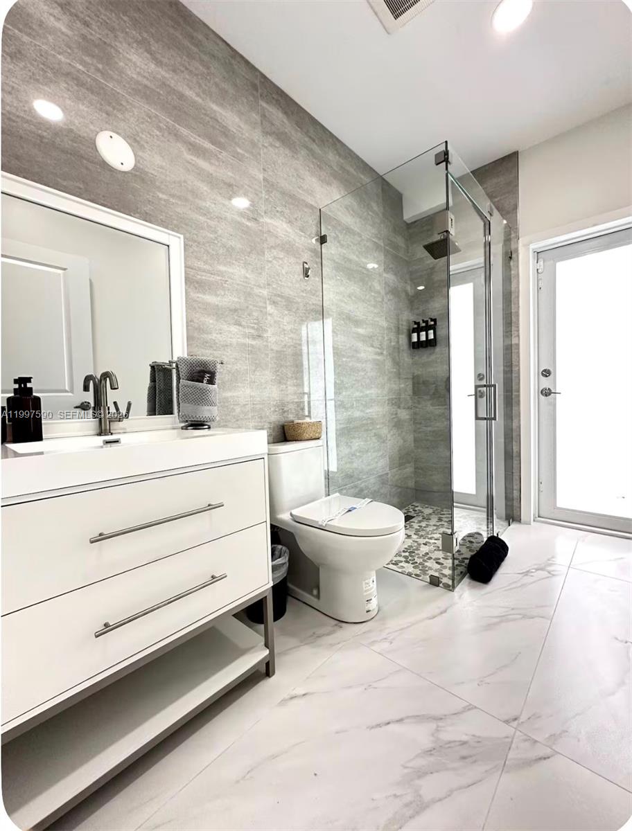 15411 Southwest 36th Terrace Miami, FL 33185 - Photo 44 of 45 a bathroom with a double vanity sink toilet and shower
