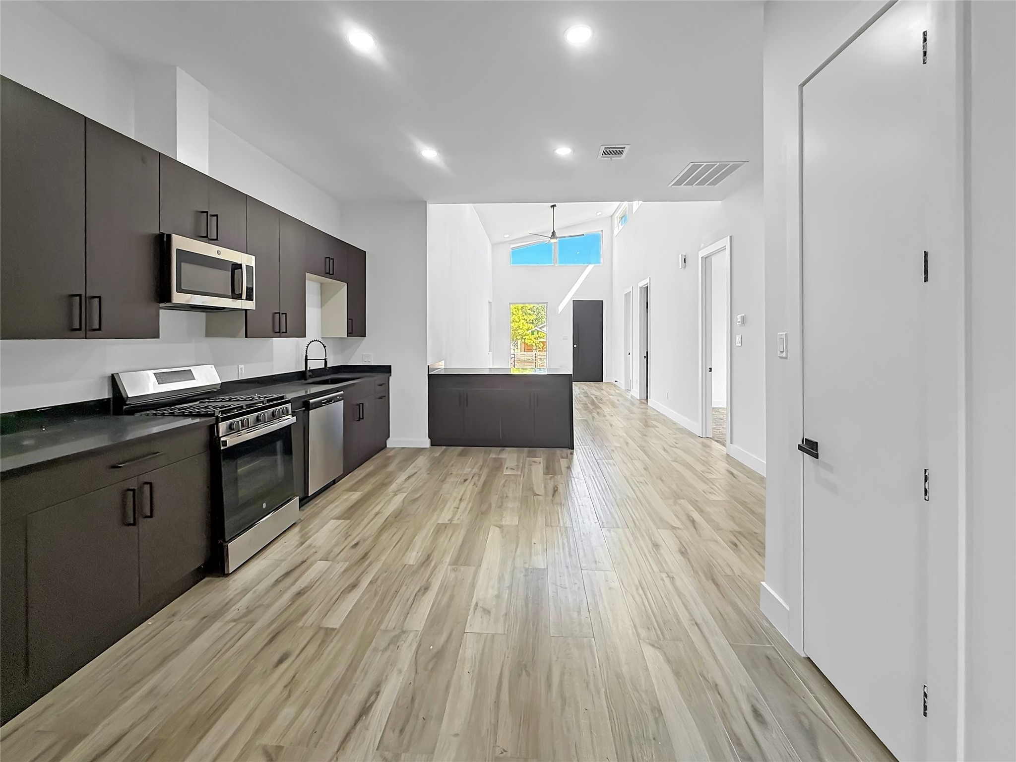 3115 Evella Street Houston, TX 77026 - Photo 11 of 21 a large kitchen with stainless steel appliances a large counter top a stove a sink and a refrigerator