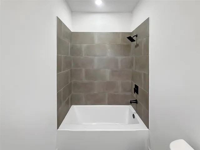 a bathroom with a granite countertop toilet and sink