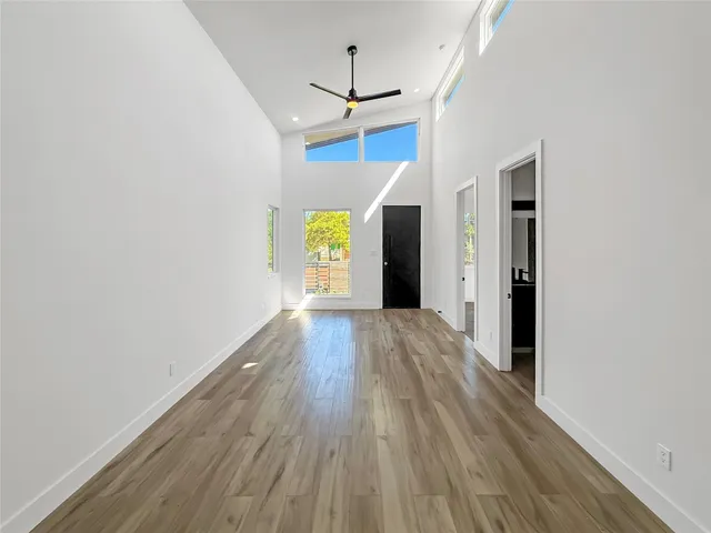 a view of empty room with wooden floor and ceiling fan