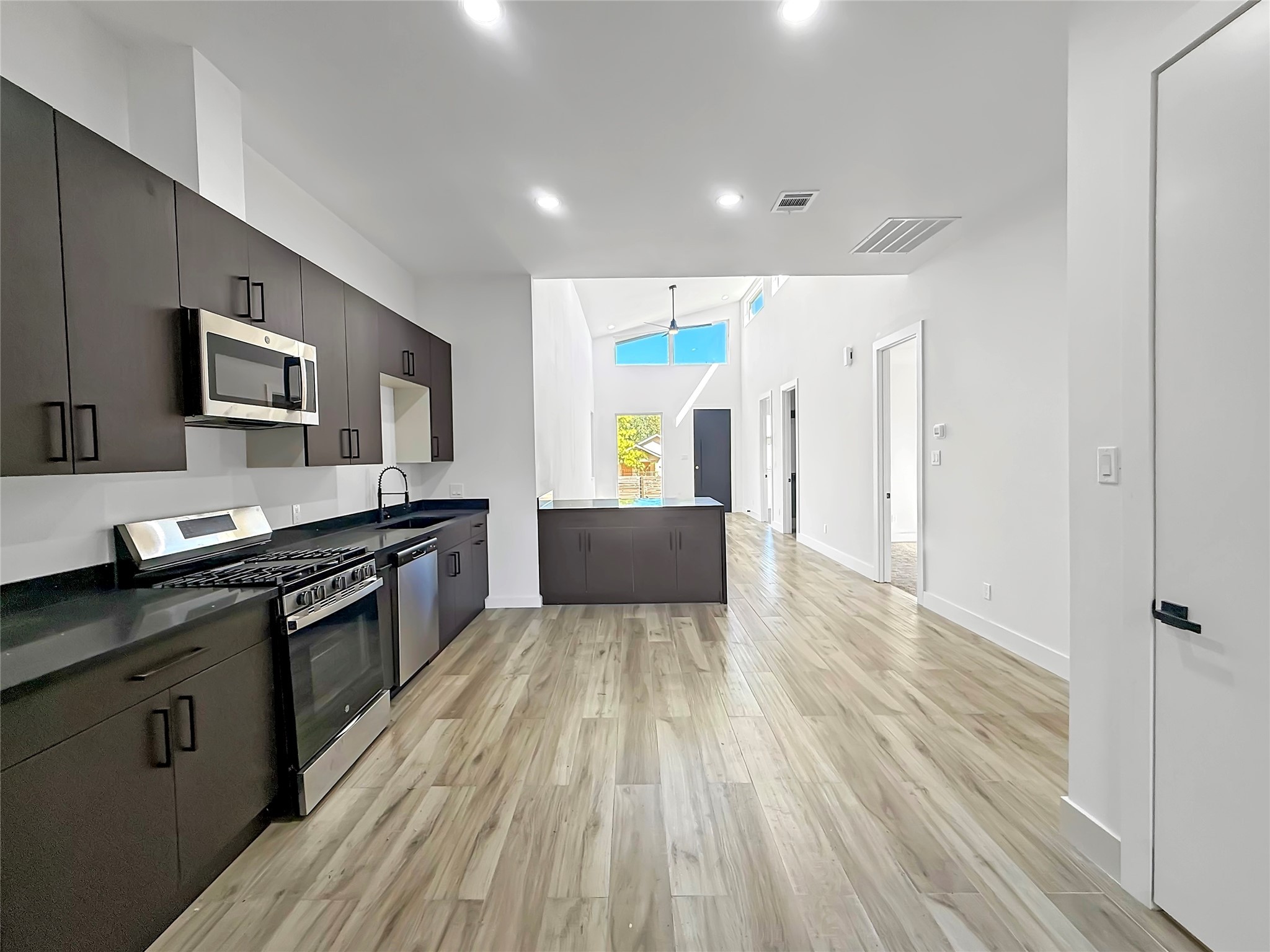 3115 Evella Street Houston, TX 77026 - Photo 10 of 21 a large kitchen with cabinets wooden floor and stainless steel appliances