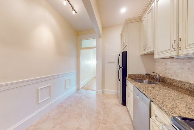 a kitchen with granite countertop a sink and a stove