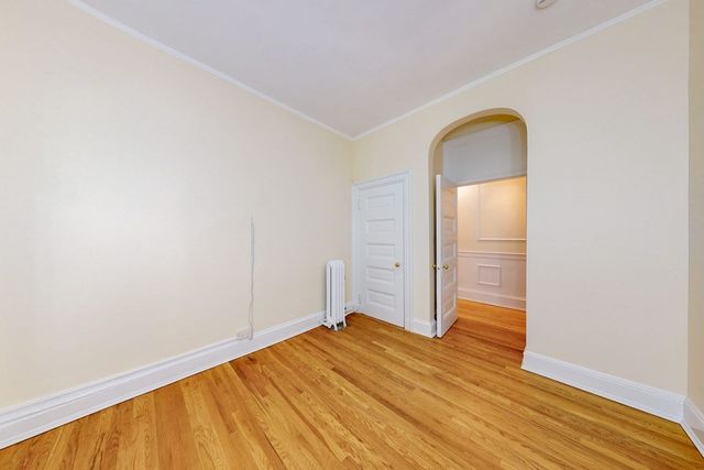 an empty room with wooden floor and closet