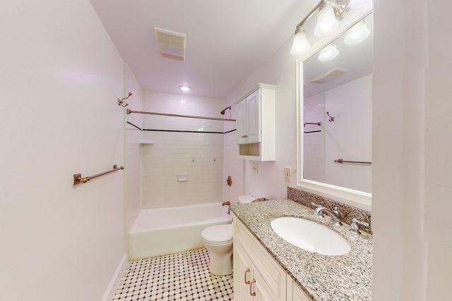 a bathroom with a granite countertop sink toilet a shower and a mirror