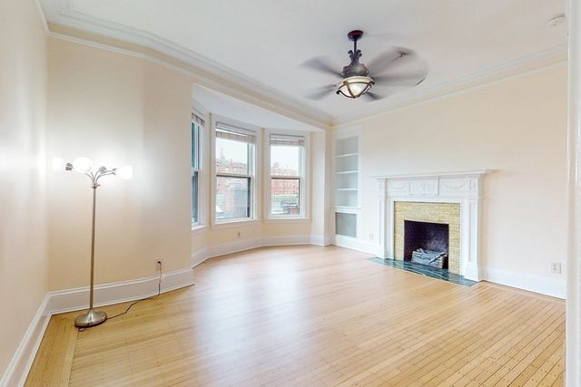 a view of an empty room with a fireplace and a window