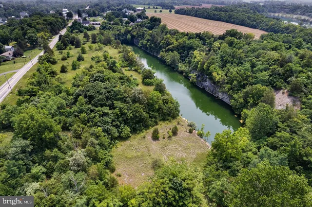 an aerial view of residential house with outdoor space and trees all around