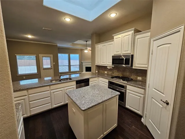 a kitchen with stainless steel appliances granite countertop a stove a sink and a refrigerator