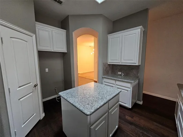 a kitchen with cabinets appliances and a wooden floor