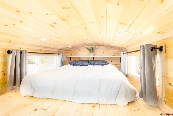 a large bed sitting in a bedroom next to a window