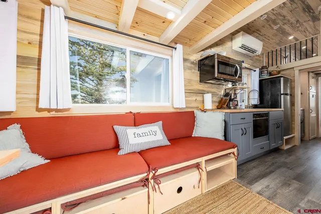 a living room with furniture a flat screen tv and a floor to ceiling window