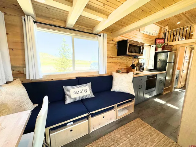 a view of a kitchen with stainless steel appliances wooden floor and a window