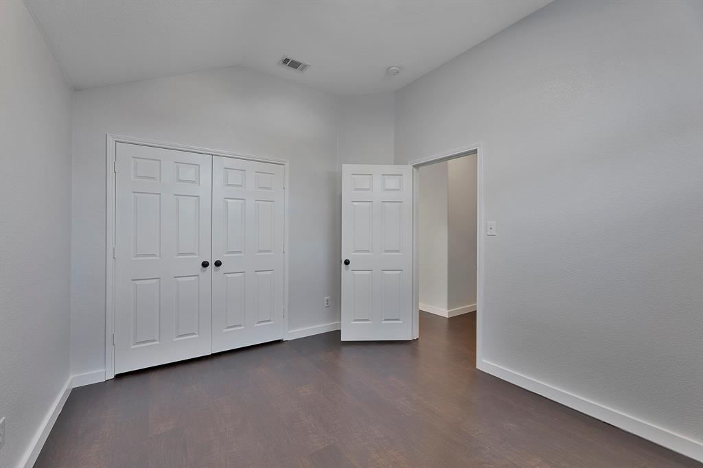 605 Clearbrook Street Azle, TX 76020 - Photo 4 of 33 Bedroom featuring wood-finish flooring, a vaulted ceiling, a paneled bifold closet, white baseboards, and a paneled interior door