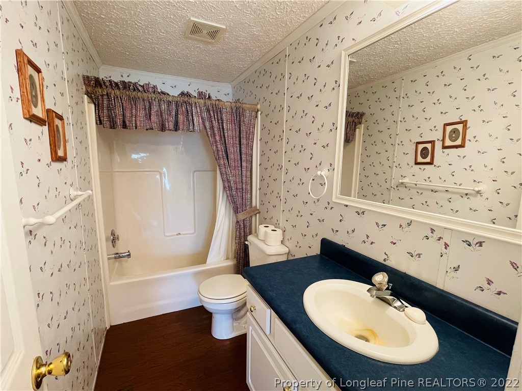 4684 East Raynham Road Fairmont, NC 28340 - Photo 17 of 26 a bathroom with a toilet sink and mirror