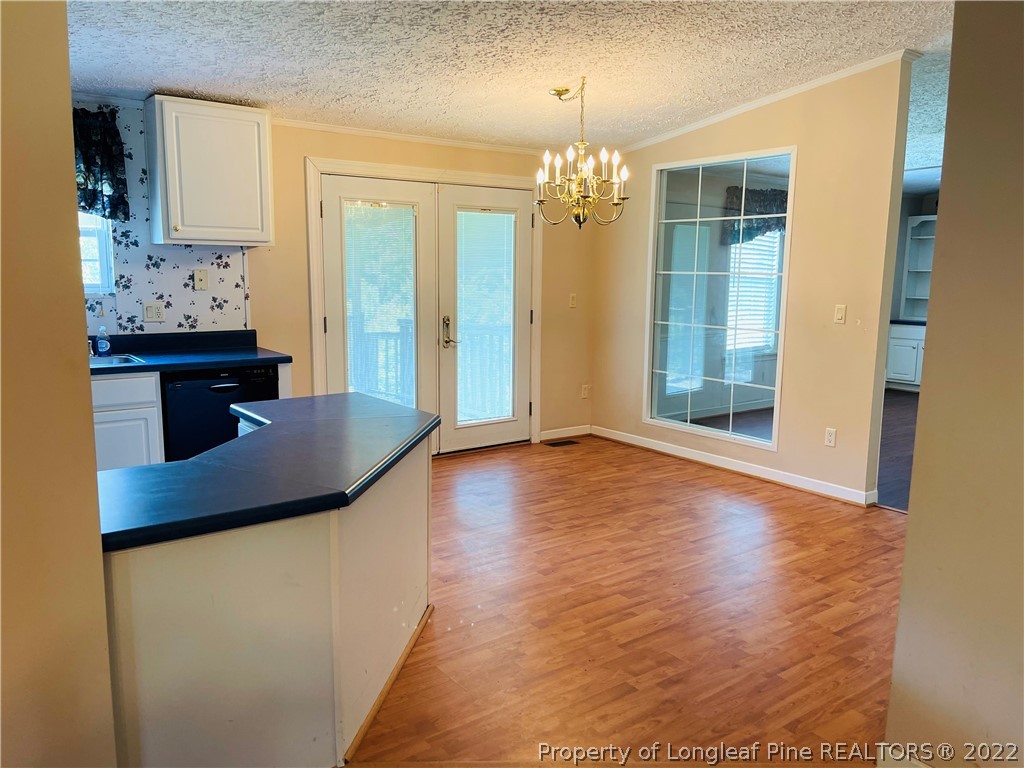 4684 East Raynham Road Fairmont, NC 28340 - Photo 6 of 26 a view of a livingroom with wooden floor and kitchen space