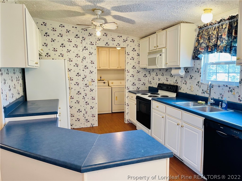 4684 East Raynham Road Fairmont, NC 28340 - Photo 7 of 26 a kitchen with granite countertop a sink stainless steel appliances and cabinets