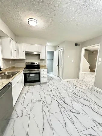 a large kitchen with stainless steel appliances kitchen island granite countertop a sink and cabinets
