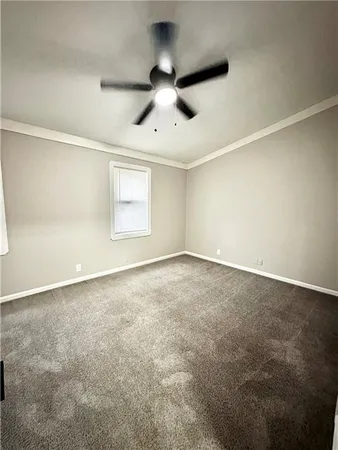 an empty room with a ceiling fan and window