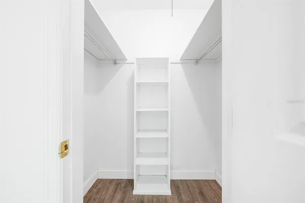 a view of walk in closet with empty racks