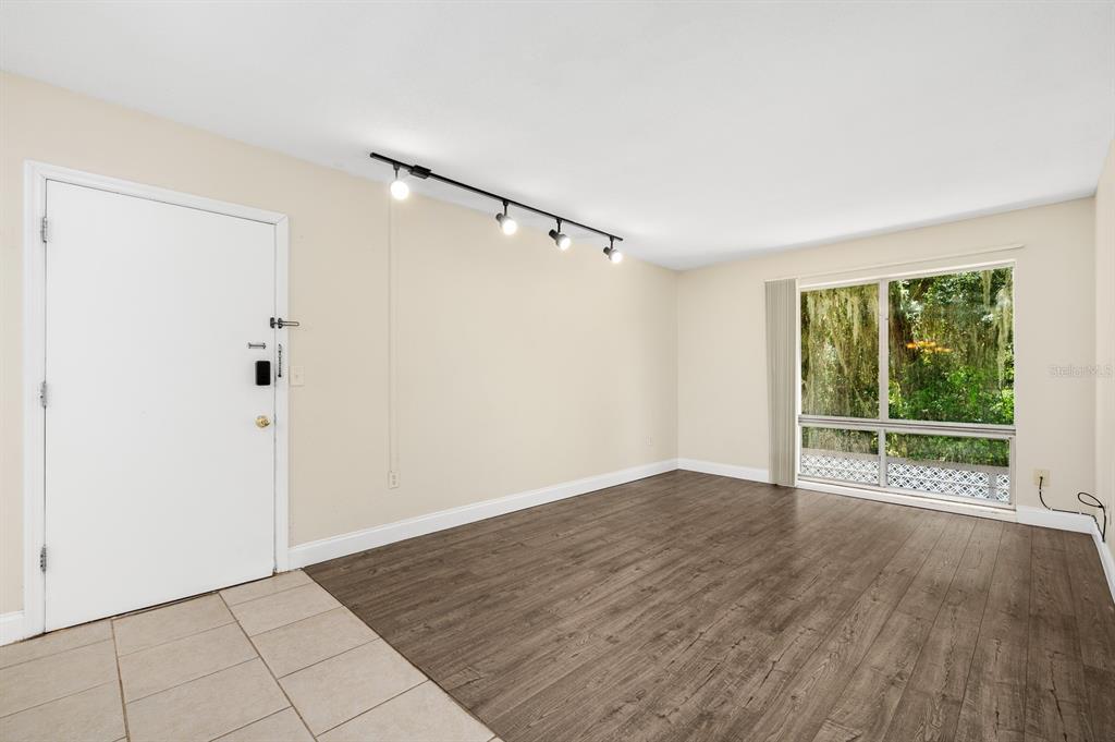 1700 Southwest 16th Court, Unit L26 Gainesville, FL 32608 - Photo 5 of 24 a view of an empty room with wooden floor and a window