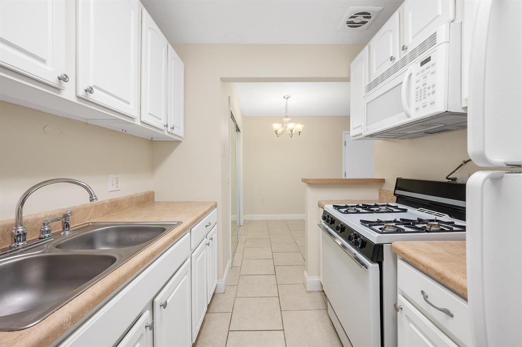 1700 Southwest 16th Court, Unit L26 Gainesville, FL 32608 - Photo 8 of 24 a kitchen with stainless steel appliances granite countertop a sink stove and cabinets