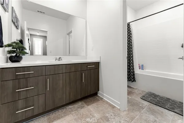 a spacious bedroom with a bed and a flat screen tv