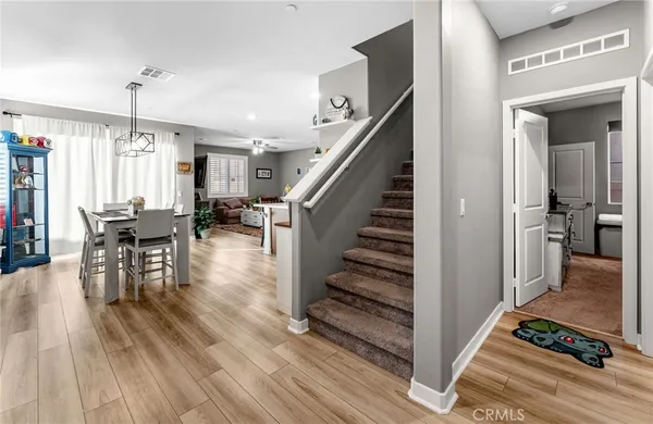 a kitchen with stainless steel appliances kitchen island granite countertop a table chairs and a refrigerator