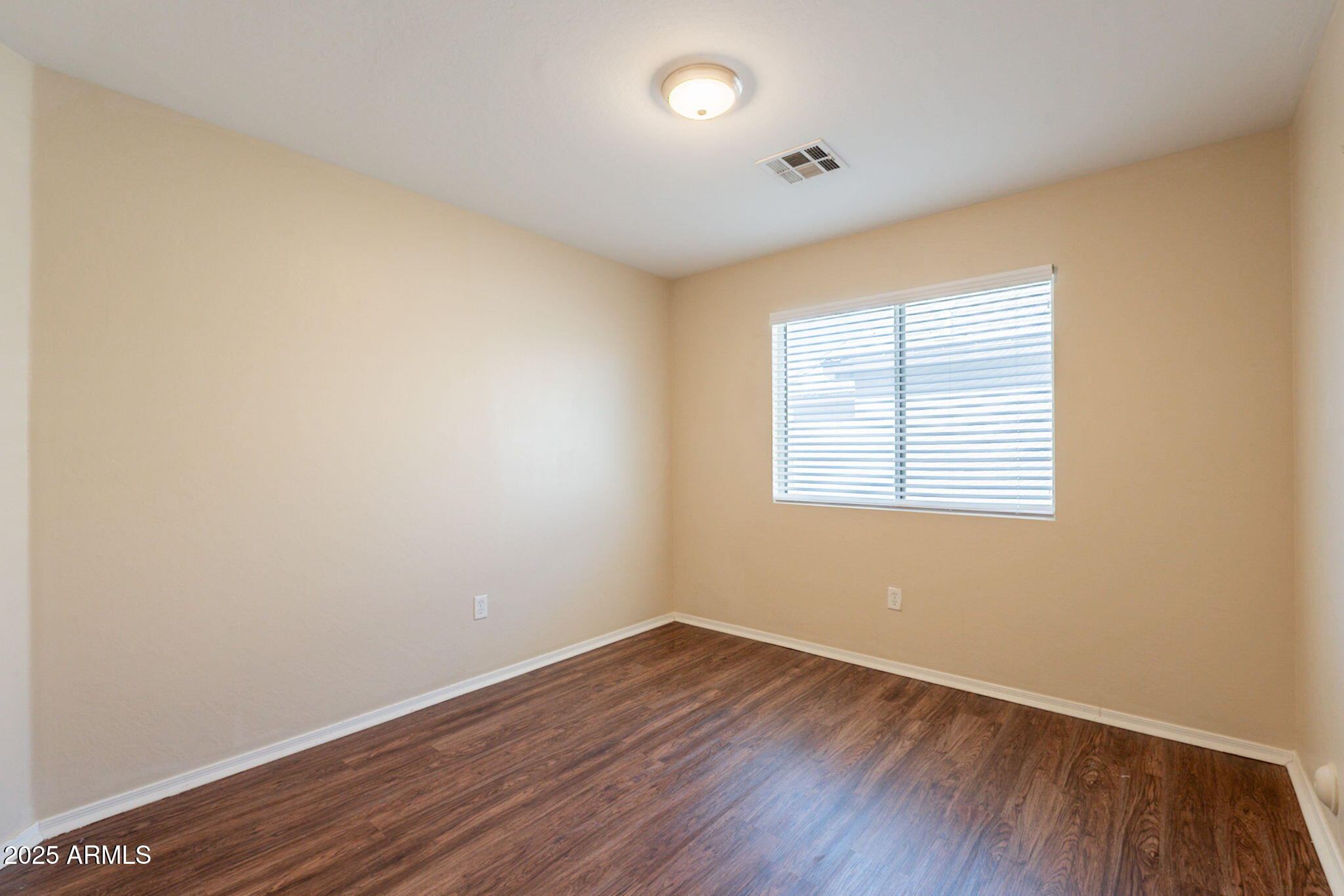 4010 West Fremont Rd. Phoenix, AZ 85041 - Photo 23 of 46 an empty room with wooden floor and windows