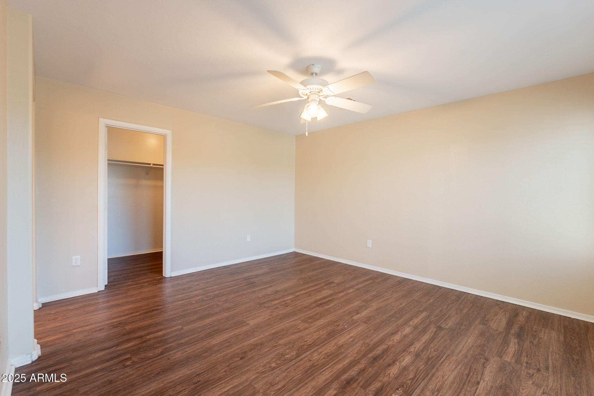 4010 West Fremont Rd. Phoenix, AZ 85041 - Photo 29 of 46 a view of an empty room with wooden floor and a ceiling fan