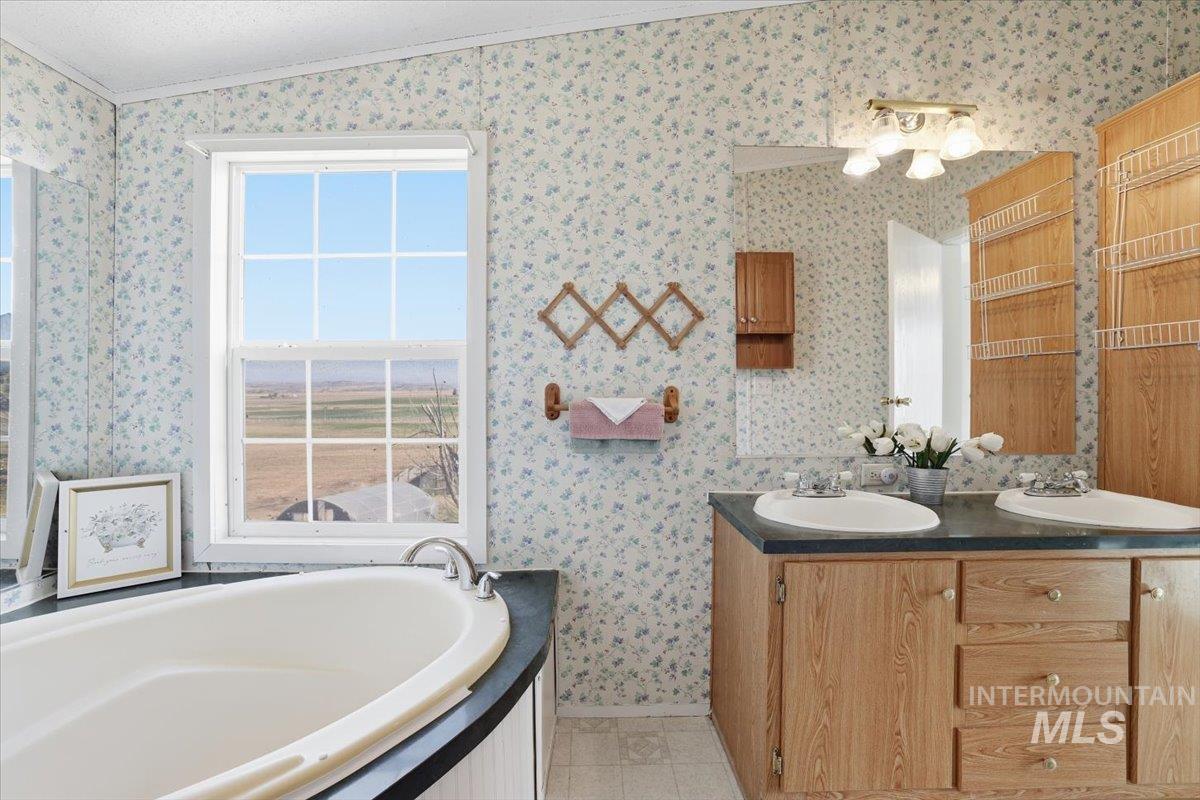 4207 West Pershall Road Marsing, ID 83639 - Photo 24 of 42 Full bathroom with a bath, crown molding, double vanity, and wallpapered walls