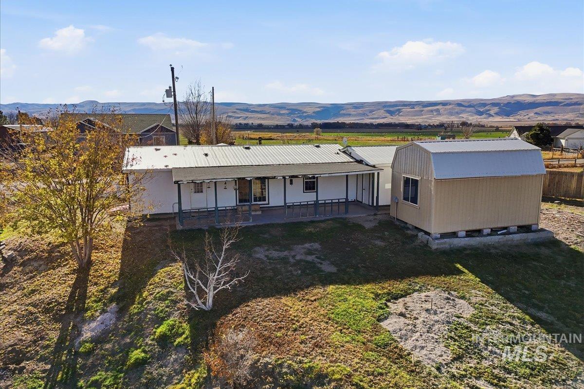4207 West Pershall Road Marsing, ID 83639 - Photo 8 of 42 Back of house with a mountain view, a lawn, and a metal roof