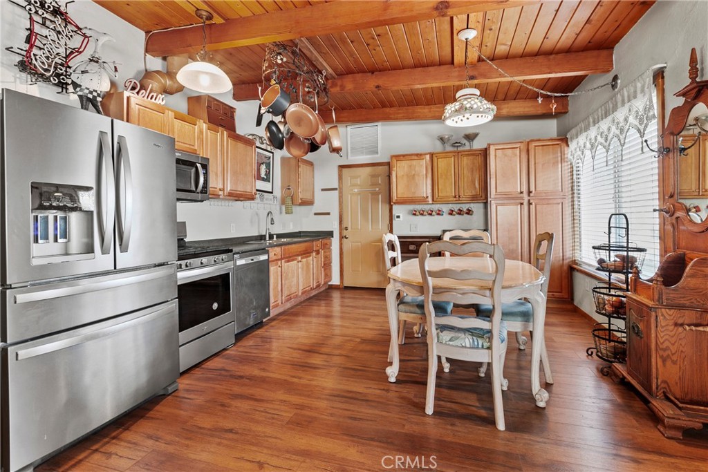 3201 Tide Avenue Morro Bay, CA 93442 - Photo 7 of 30 a kitchen with stainless steel appliances granite countertop a stove top oven a dining table and chairs with wooden floor