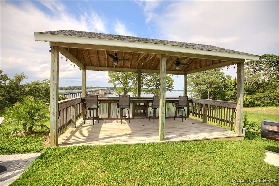 154 Twiggs Ferry Road Dutton, VA 23050 - Photo 20 of 50 Deck featuring exterior bar, a gazebo, ceiling fan, and a lawn
