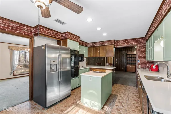 a kitchen with stainless steel appliances granite countertop a refrigerator a stove and a sink