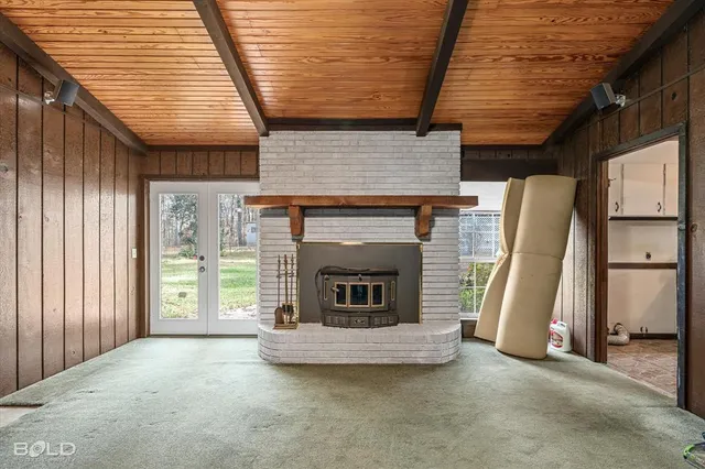 a view of an empty room with a fireplace and a window