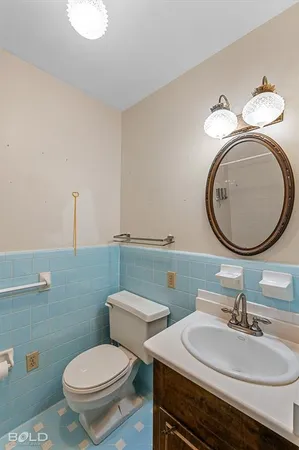 a bathroom with a granite countertop toilet a sink and a mirror