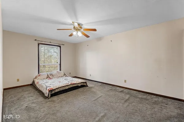 a spacious bedroom with a bed and a window