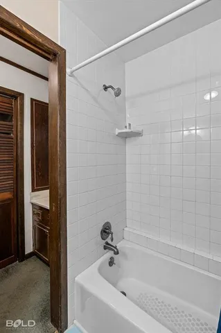 an empty room with chandelier fan and windows