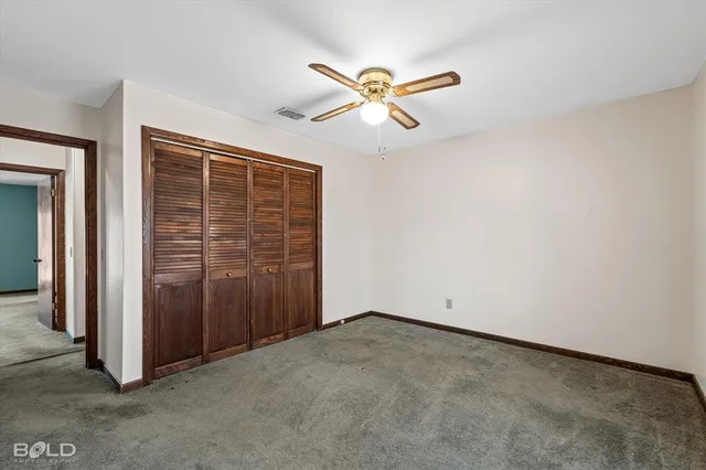 a large white kitchen with granite countertop a stove a sink and white cabinets