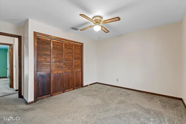 an empty room with fan and windows
