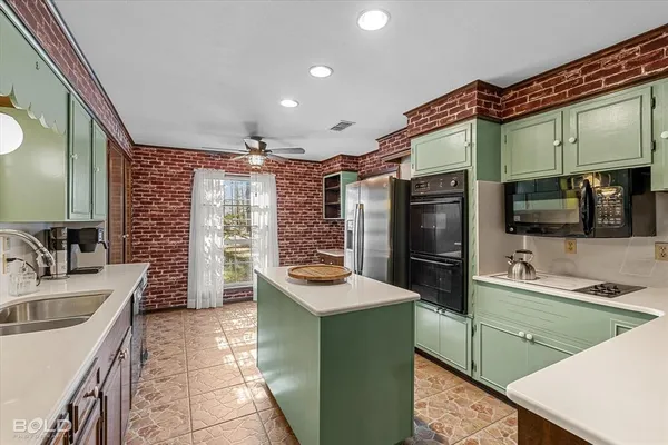 a kitchen with stainless steel appliances kitchen island granite countertop a sink and cabinets