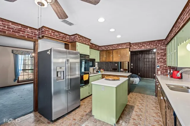 a kitchen with stainless steel appliances kitchen island granite countertop a sink and cabinets