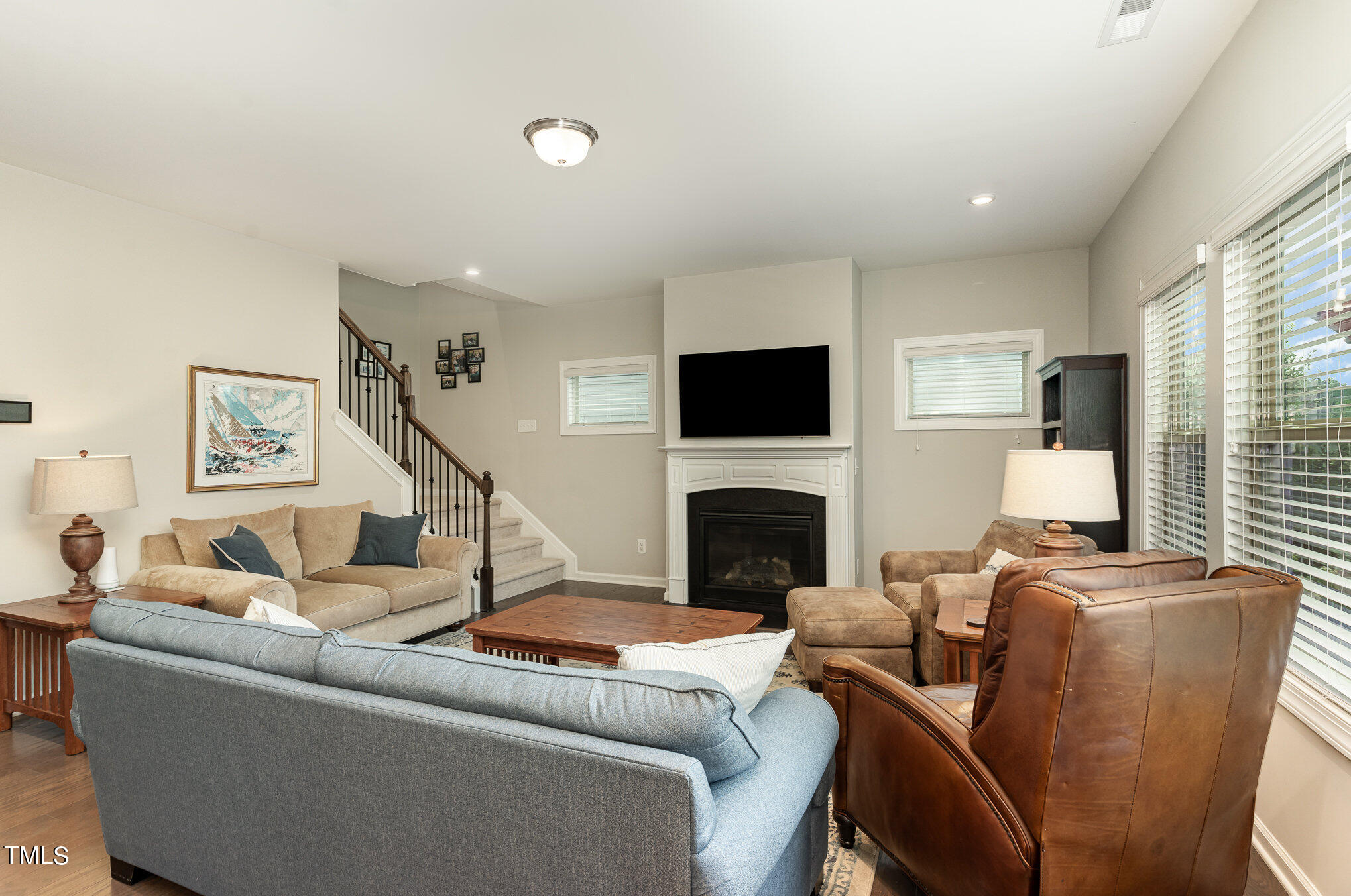 3405 Barn Road Apex, NC 27502 - Photo 11 of 38 a living room with furniture a flat screen tv and a fireplace