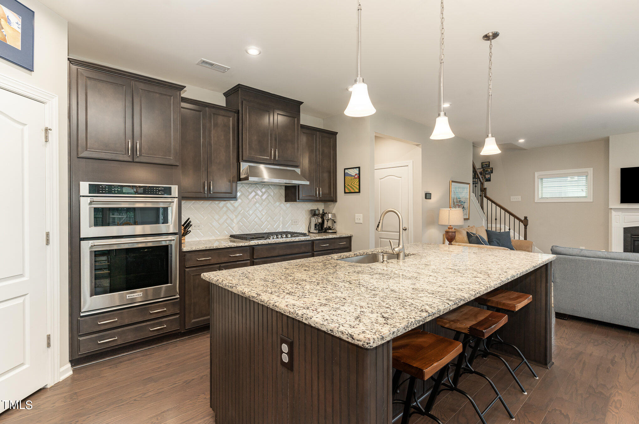 3405 Barn Road Apex, NC 27502 - Photo 13 of 38 a kitchen with a stove a kitchen island with cabinets and wooden floor