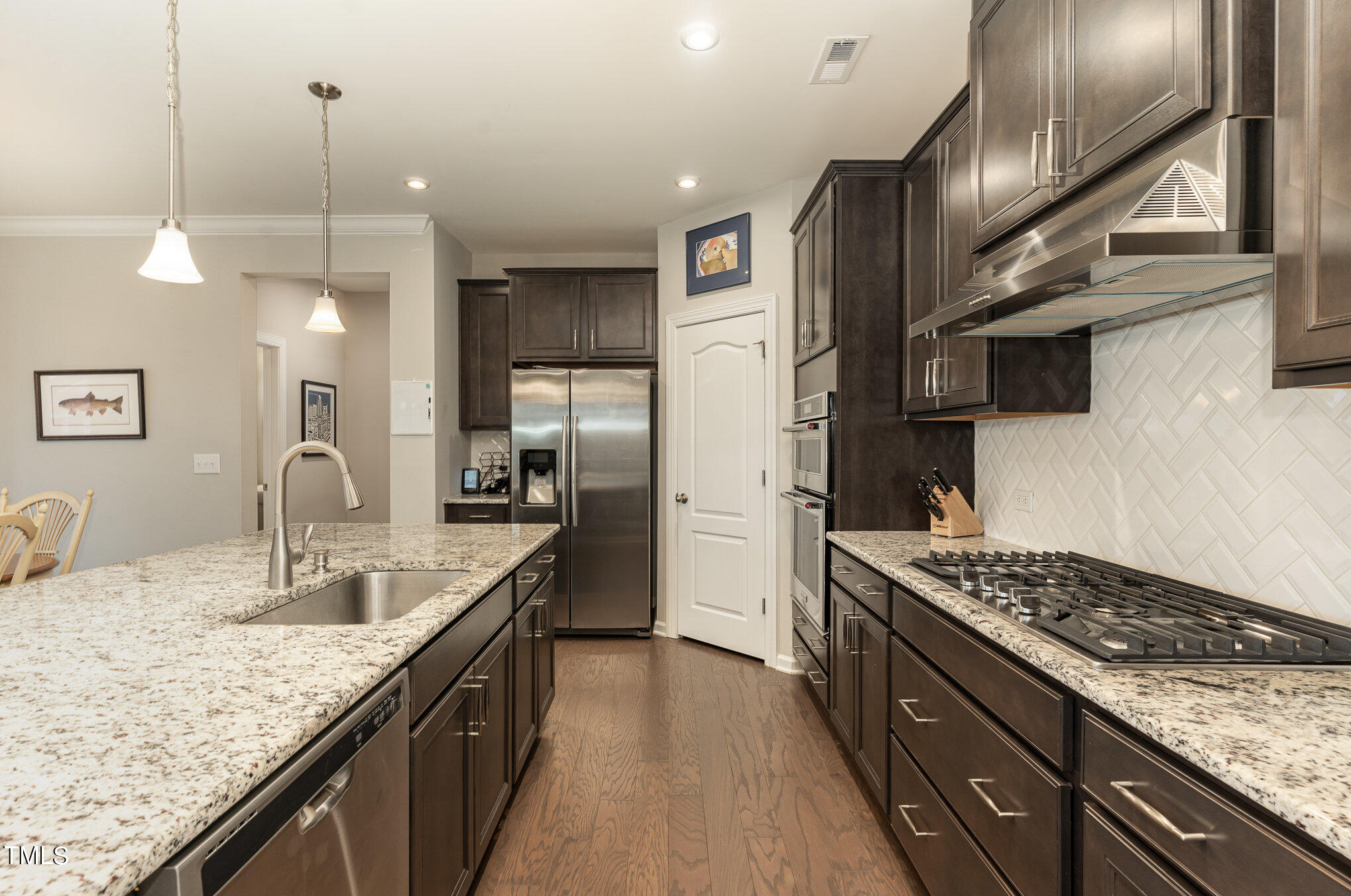 3405 Barn Road Apex, NC 27502 - Photo 14 of 38 a kitchen with granite countertop kitchen island stainless steel appliances a sink stove and refrigerator