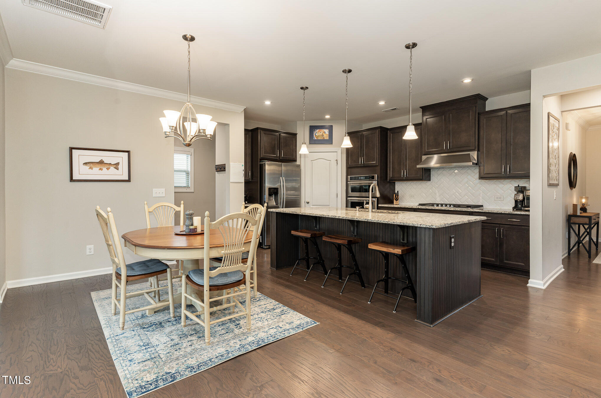 3405 Barn Road Apex, NC 27502 - Photo 16 of 38 a dining room with a table chairs and a kitchen view